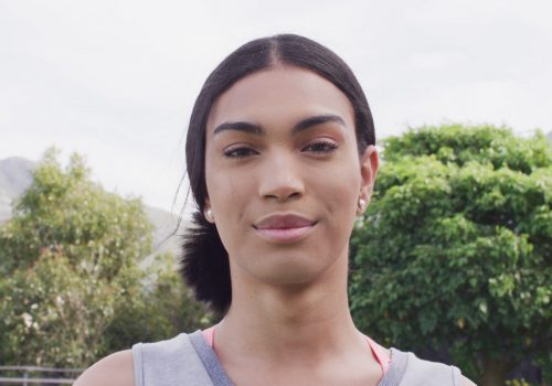 video-portrait-of-happy-biracial-non-binary-transgender-woman-smiling-to-camera-outdoo-SBI-350576871